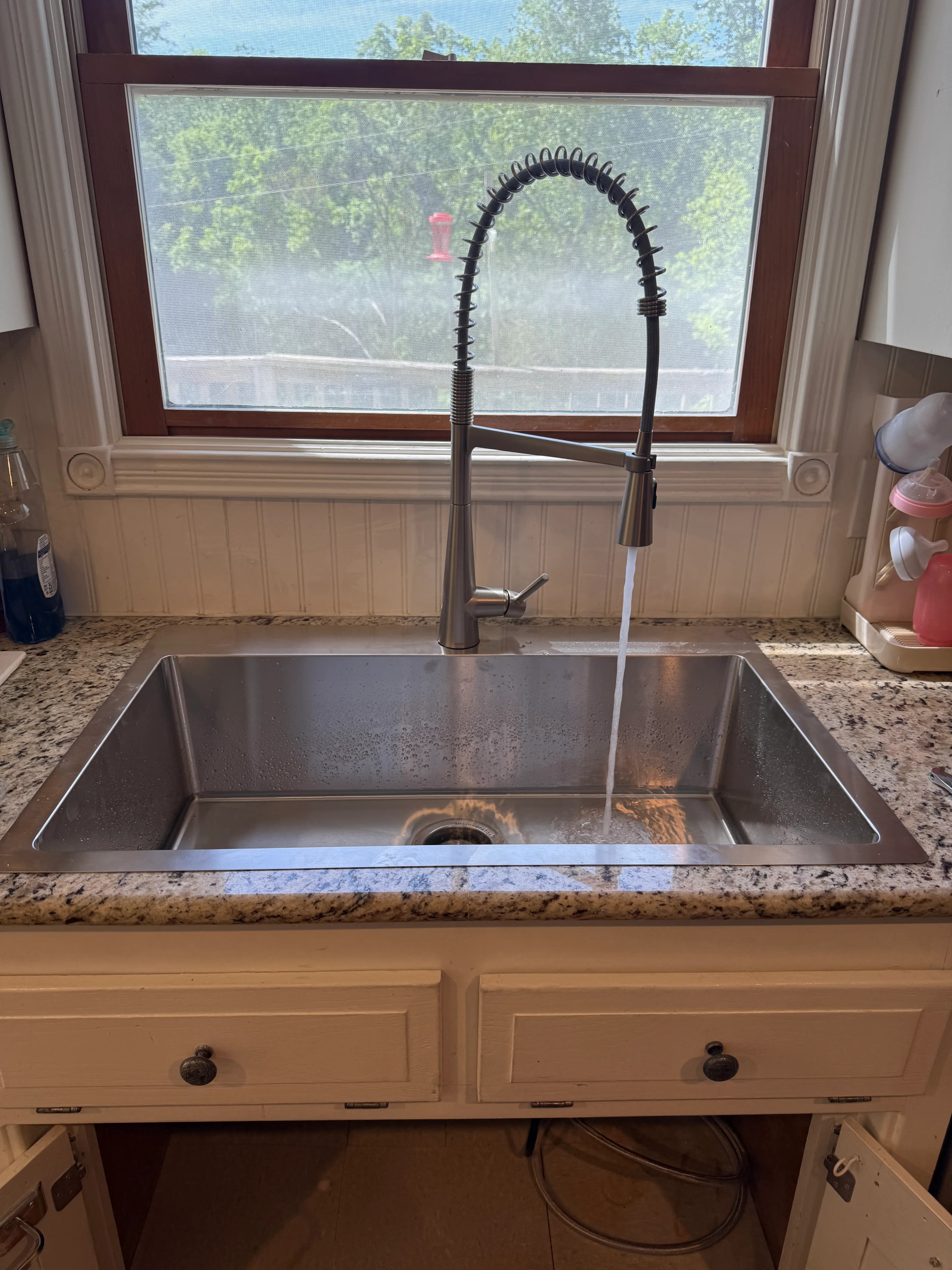 Stainless undermount kitchen sink with pull-down faucet on granite counters