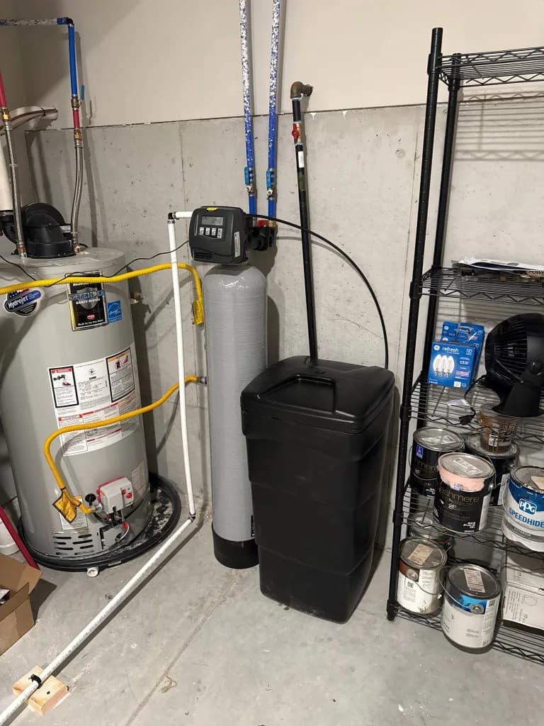 Sterling water softener control head and brine tank in a basement utility room